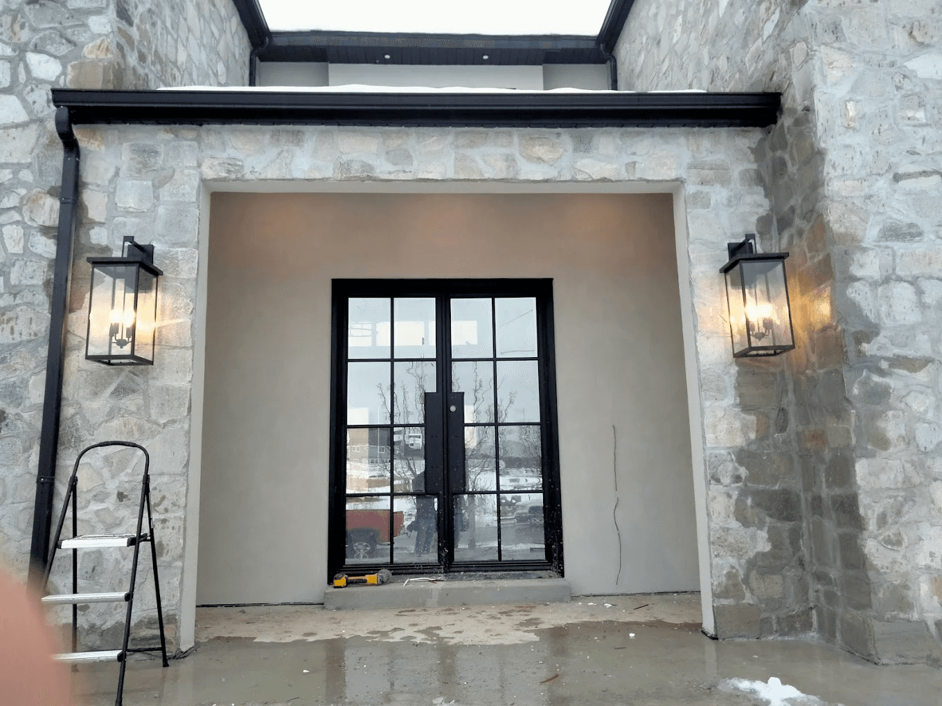 Outdoor carriage sconces installed on a stone entryway by High Desert Electric